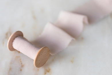 handmade and hand dyed pink silk chiffon ribbon on a wooden spool