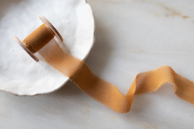 Handmade and hand dyed with all natural dyes. 100% silk ribbon with a delicately hand torn edge, sent on a wooden spool.
